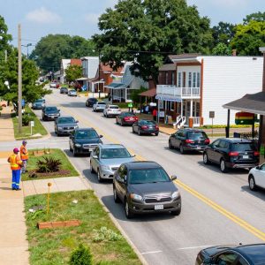 Irmo town road with traffic improvement signage and community members discussing safety measures.