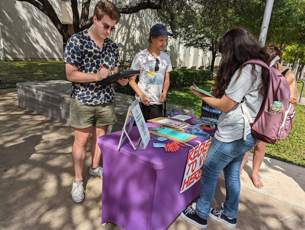 Voter registration sign at an outreach table