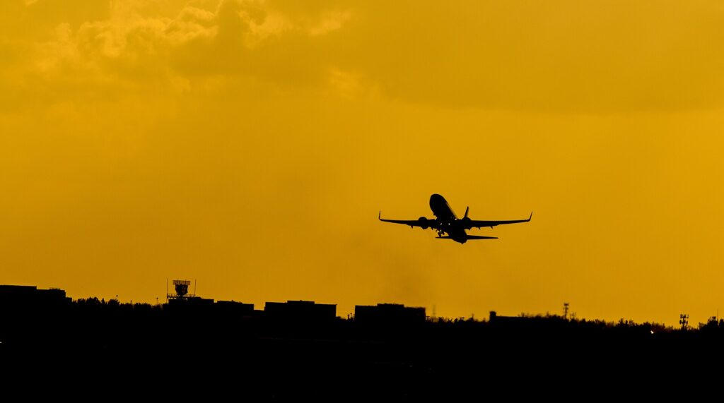 Silhouette of a single-aisle passenger jet taking off at sunset