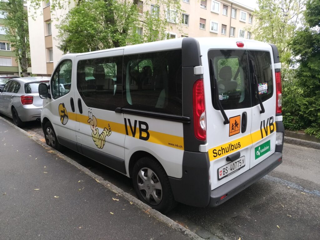 Yellow school bus parked near a school campus